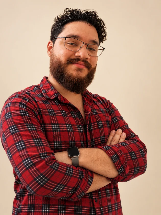 Daniël in a red checked shirt with his arms crossed